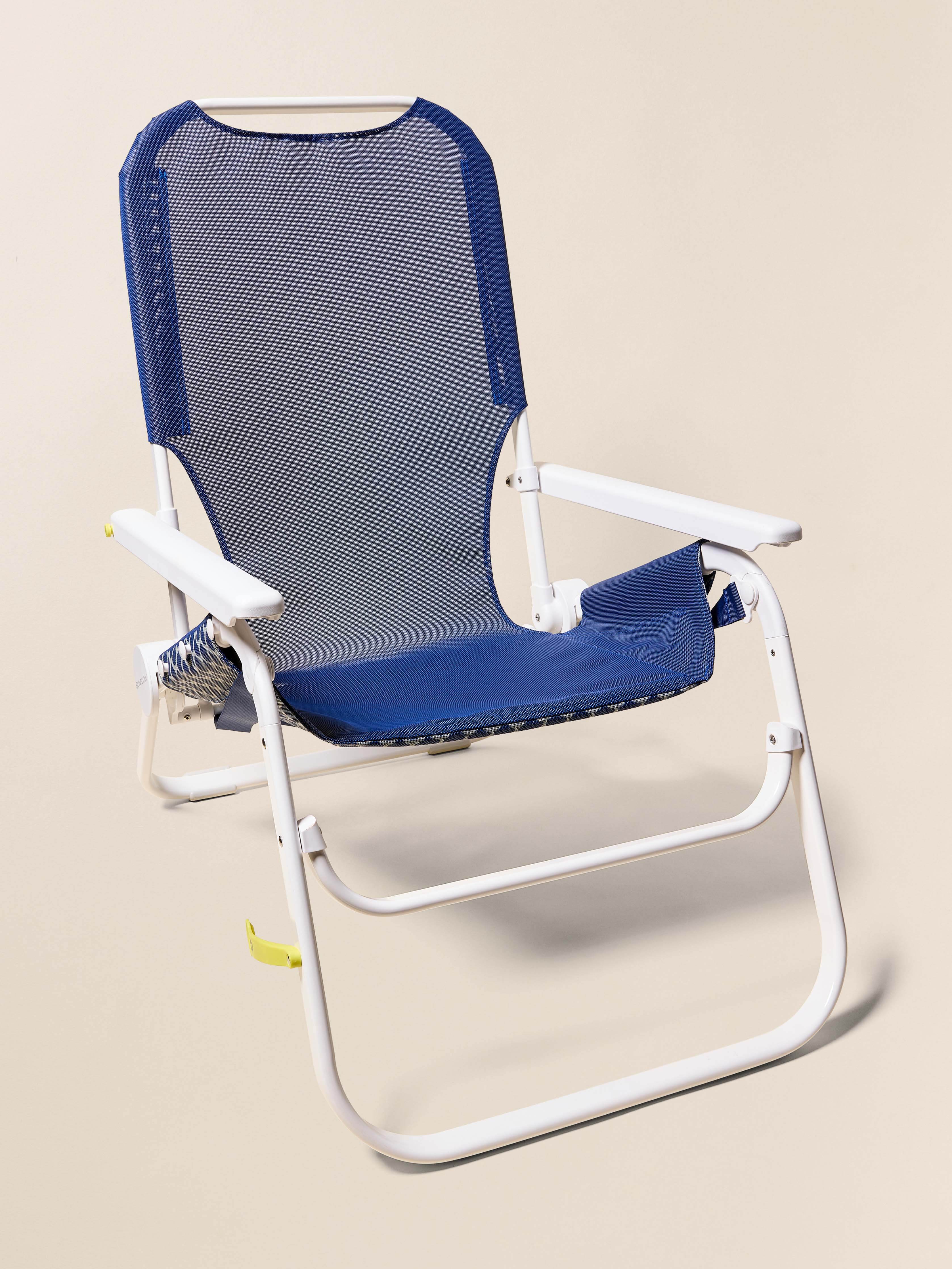 Foldable chair with blue mesh back and seat on a beige background