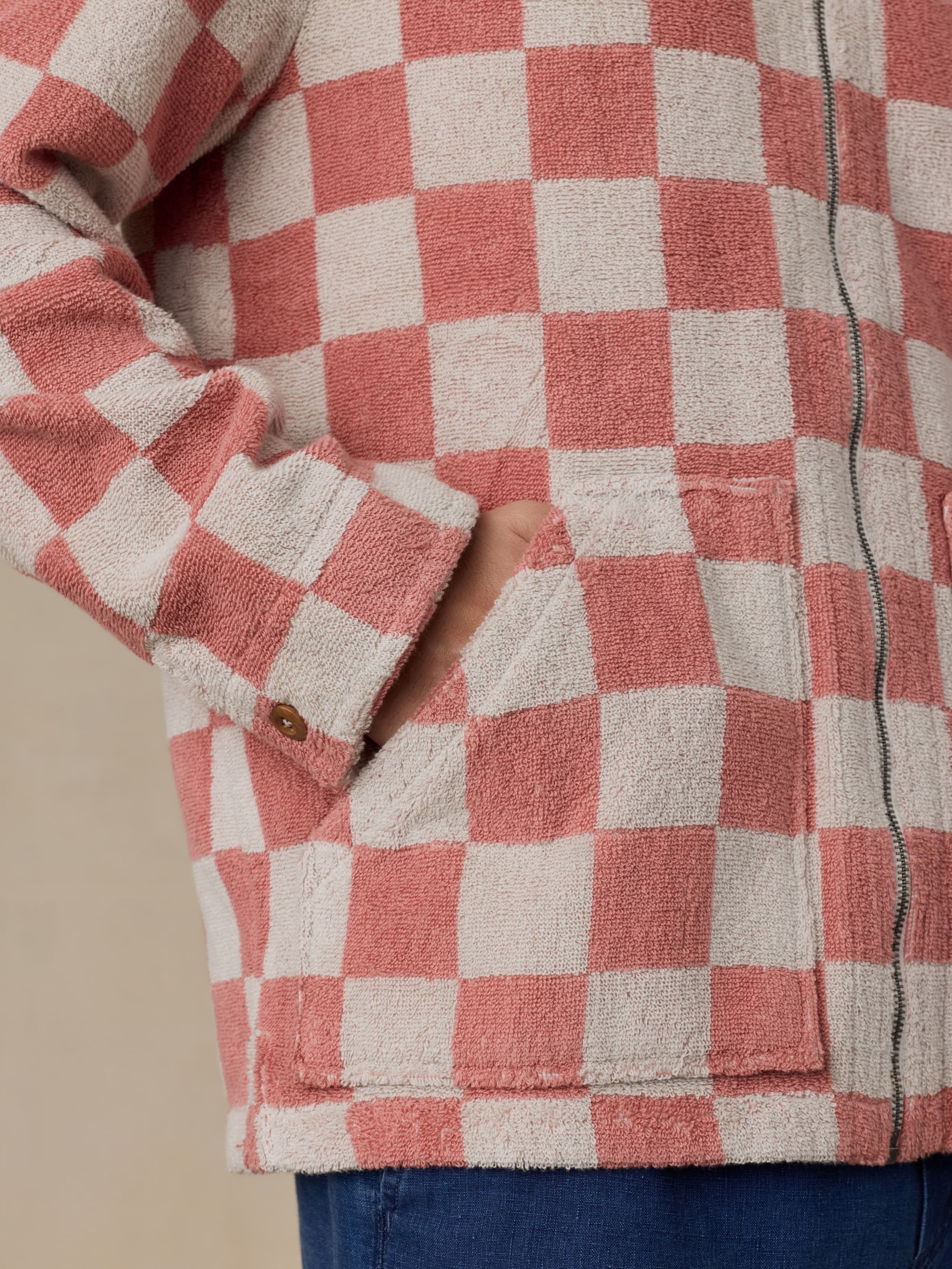 Close-up of a red and white checkered terry jacket with a beige background