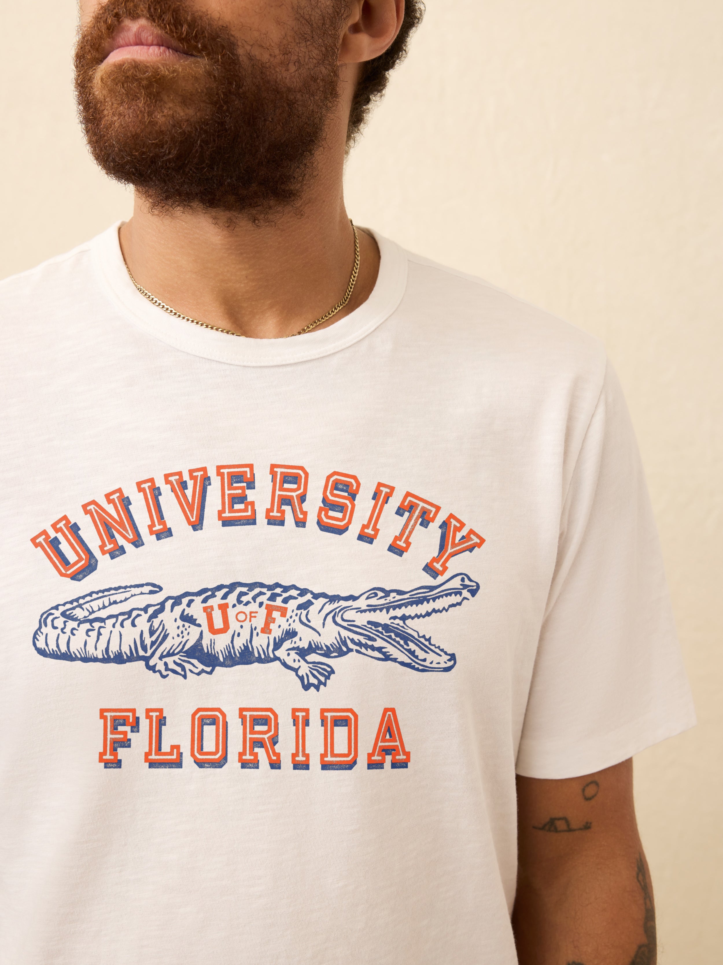 White t-shirt with University of Florida graphic on the front against beige background