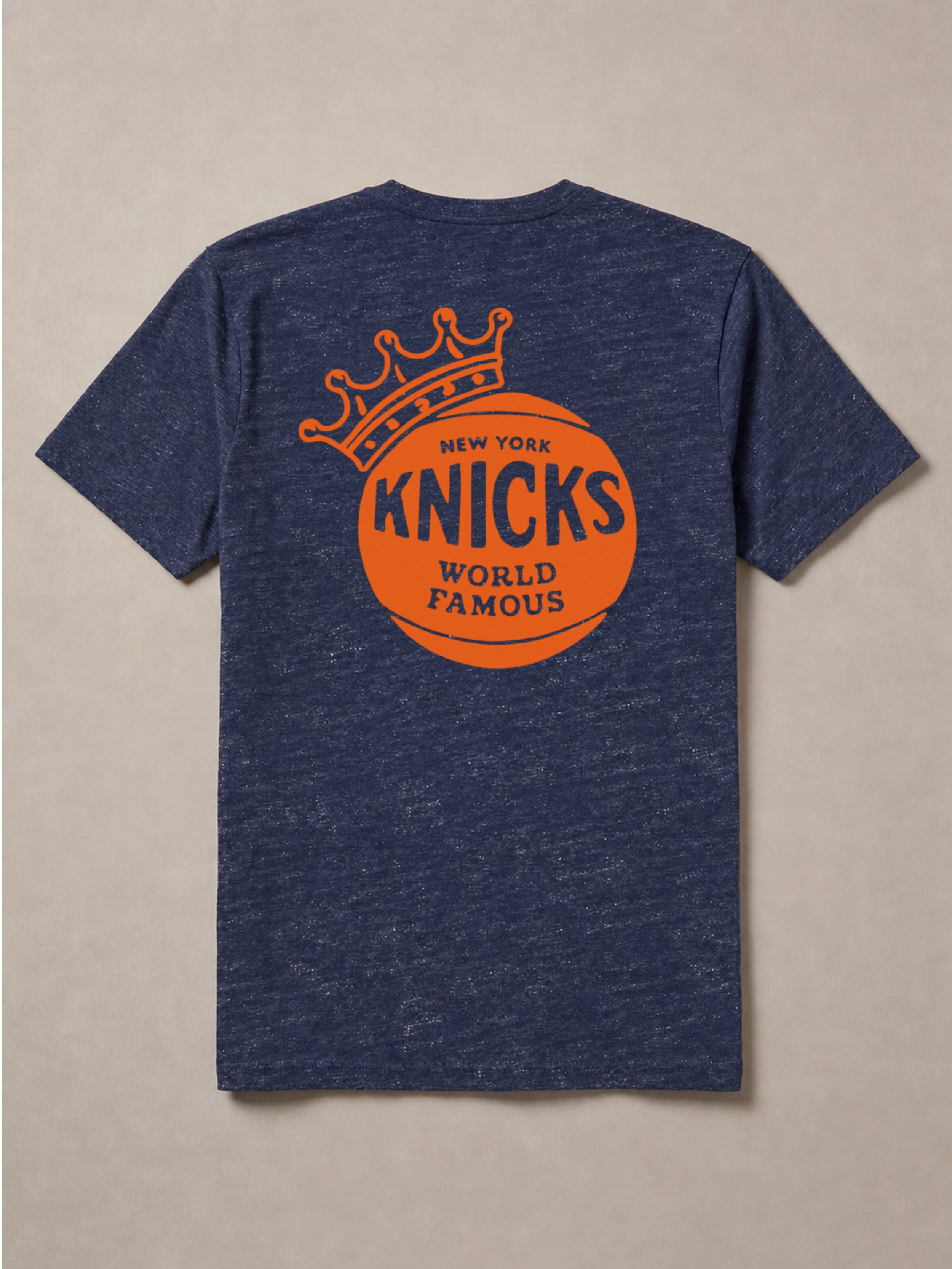 Blue t-shirt with orange 'New York Knicks World Famous' graphic on a beige background