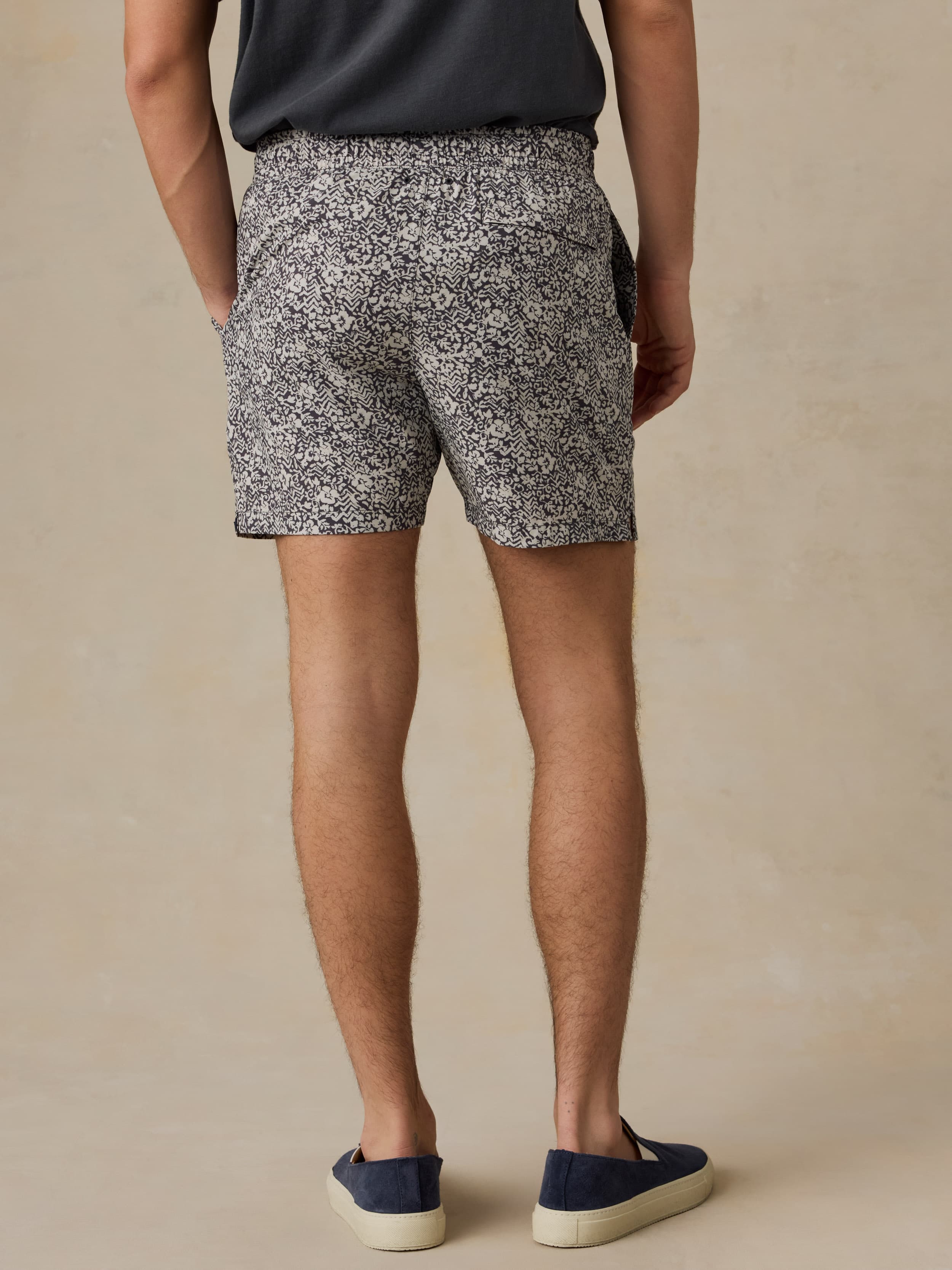 Man wearing black and white patterned shorts on a beige background