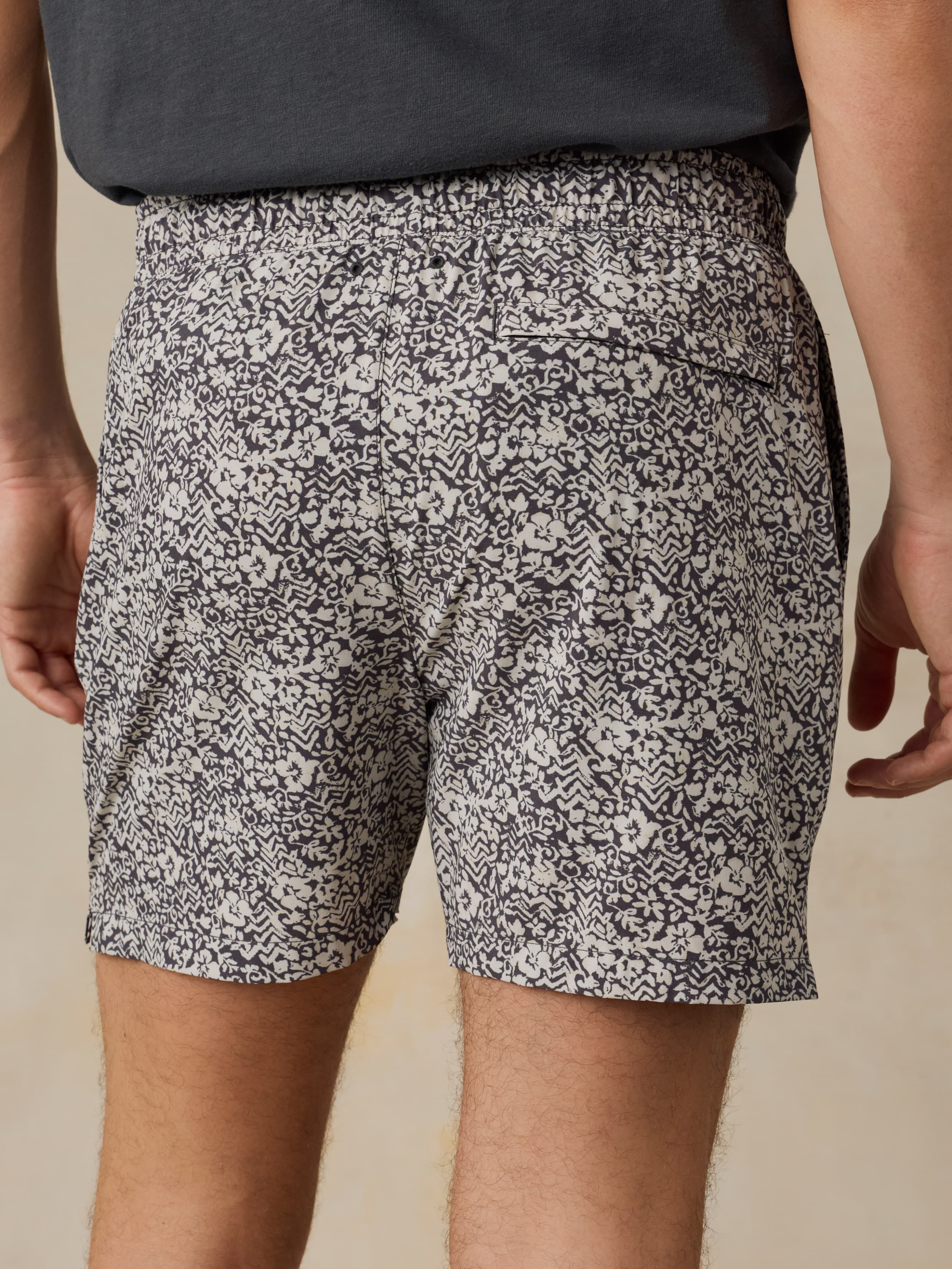 Man wearing black and white patterned shorts on a beige background