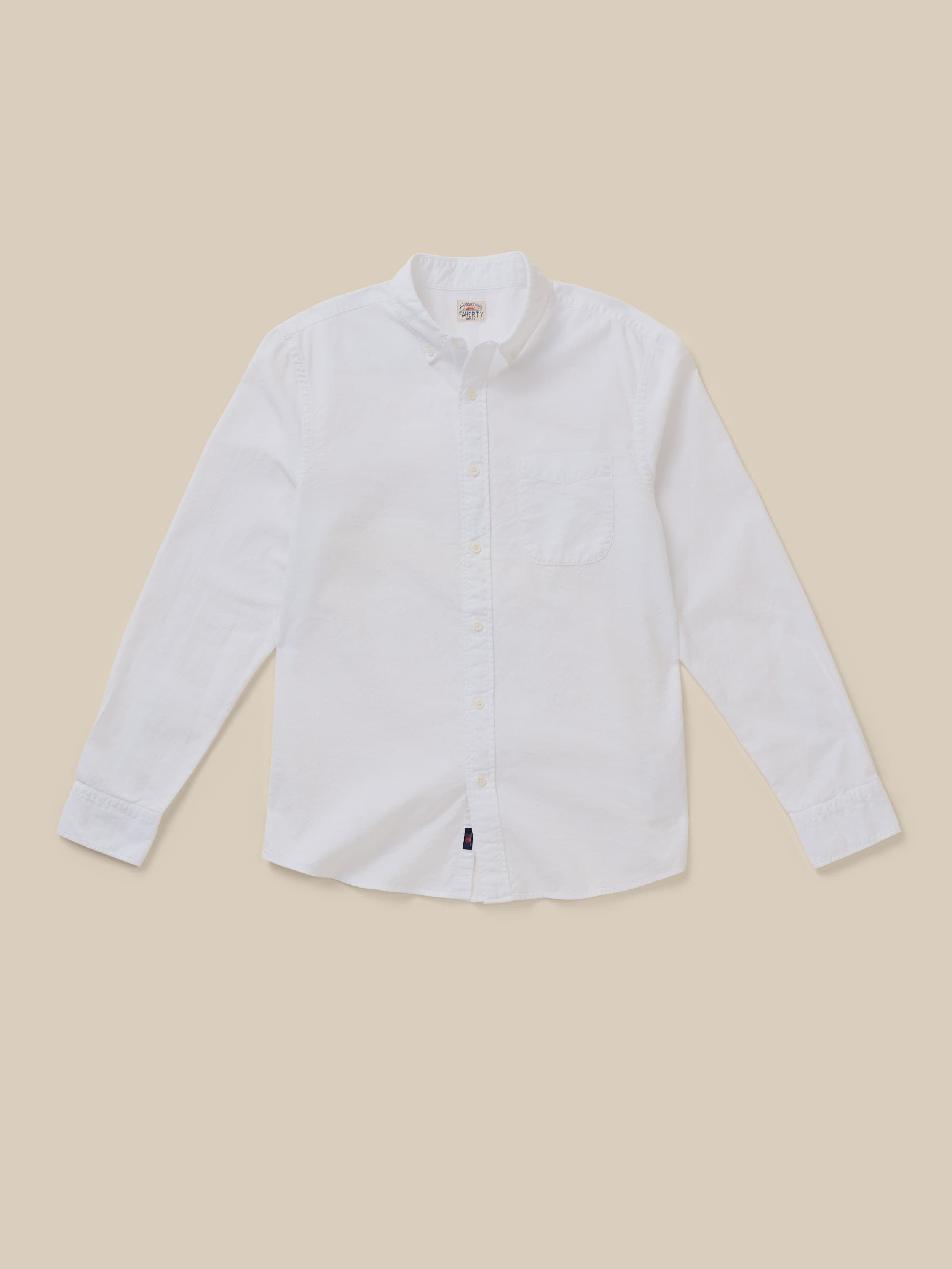 White button down shirt on a beige background