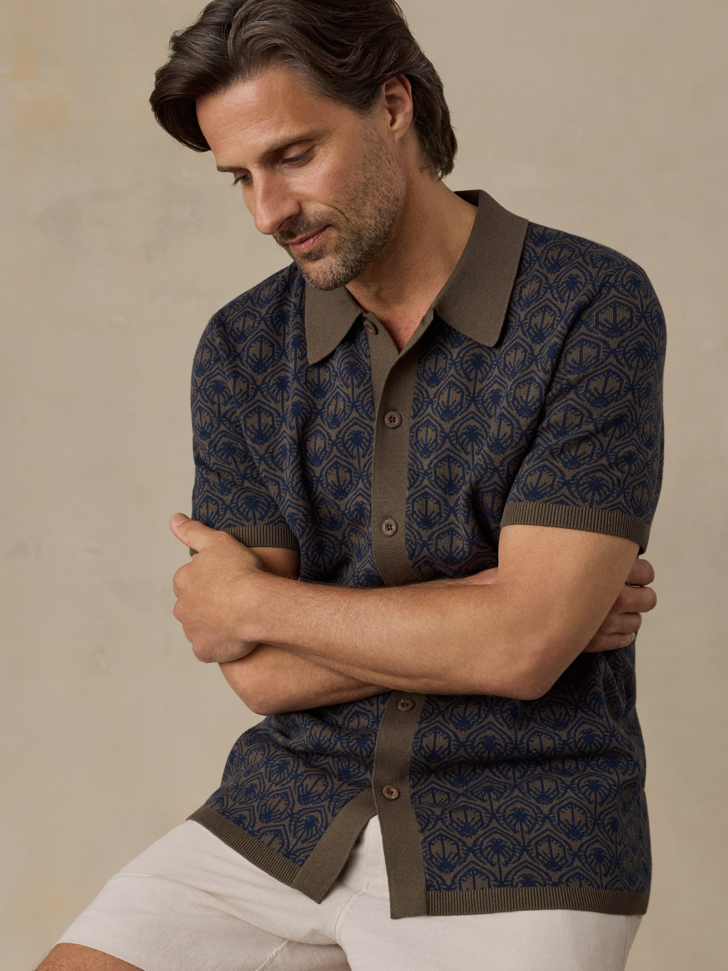 Man wearing a patterned short-sleeve shirt with a beige background