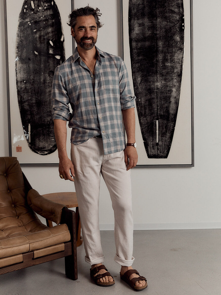Model wearing white stretch terry pants styled with a button up shirt and birkenstocks