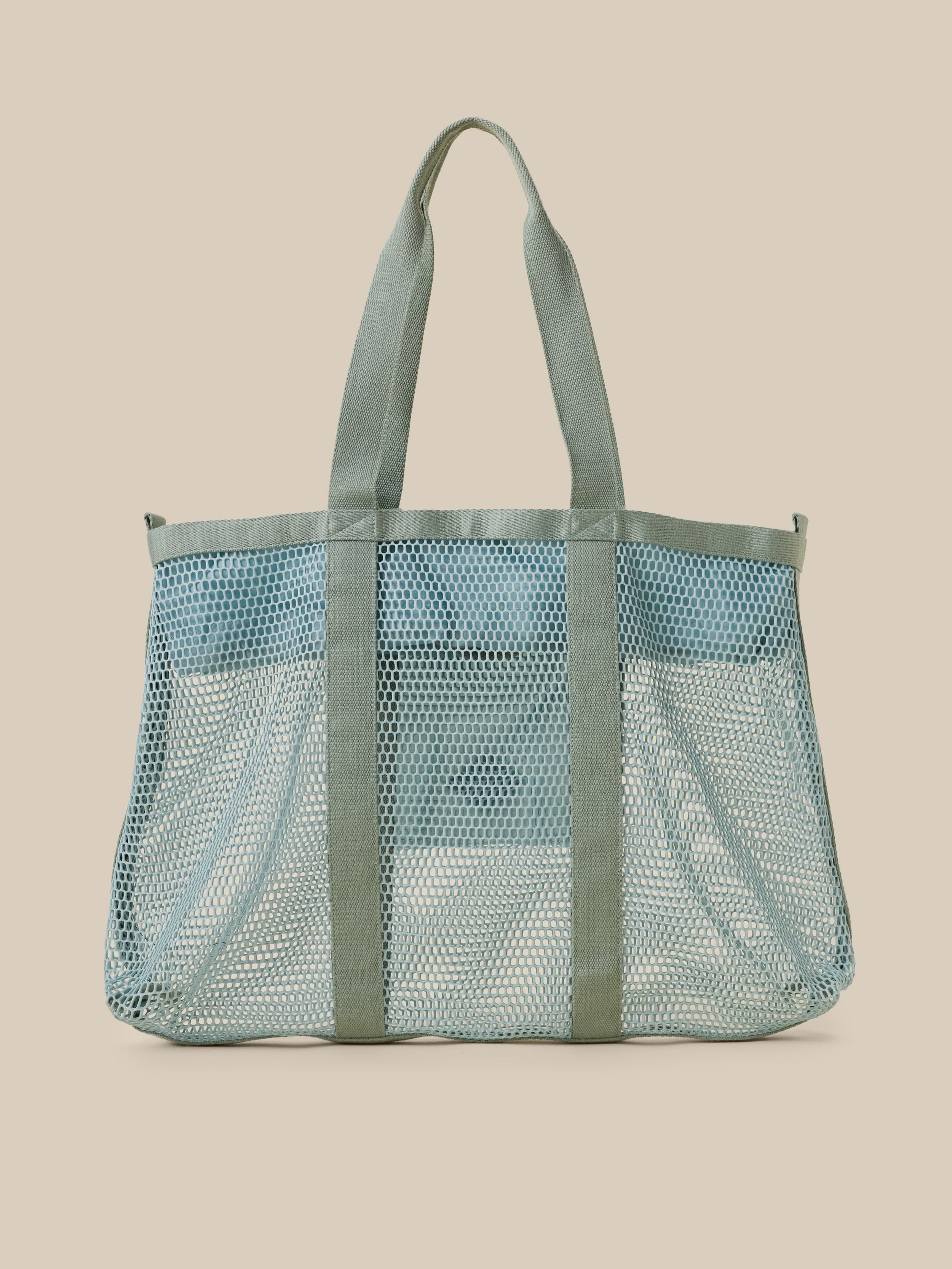 Mesh tote bag with a solid color section on a beige background
