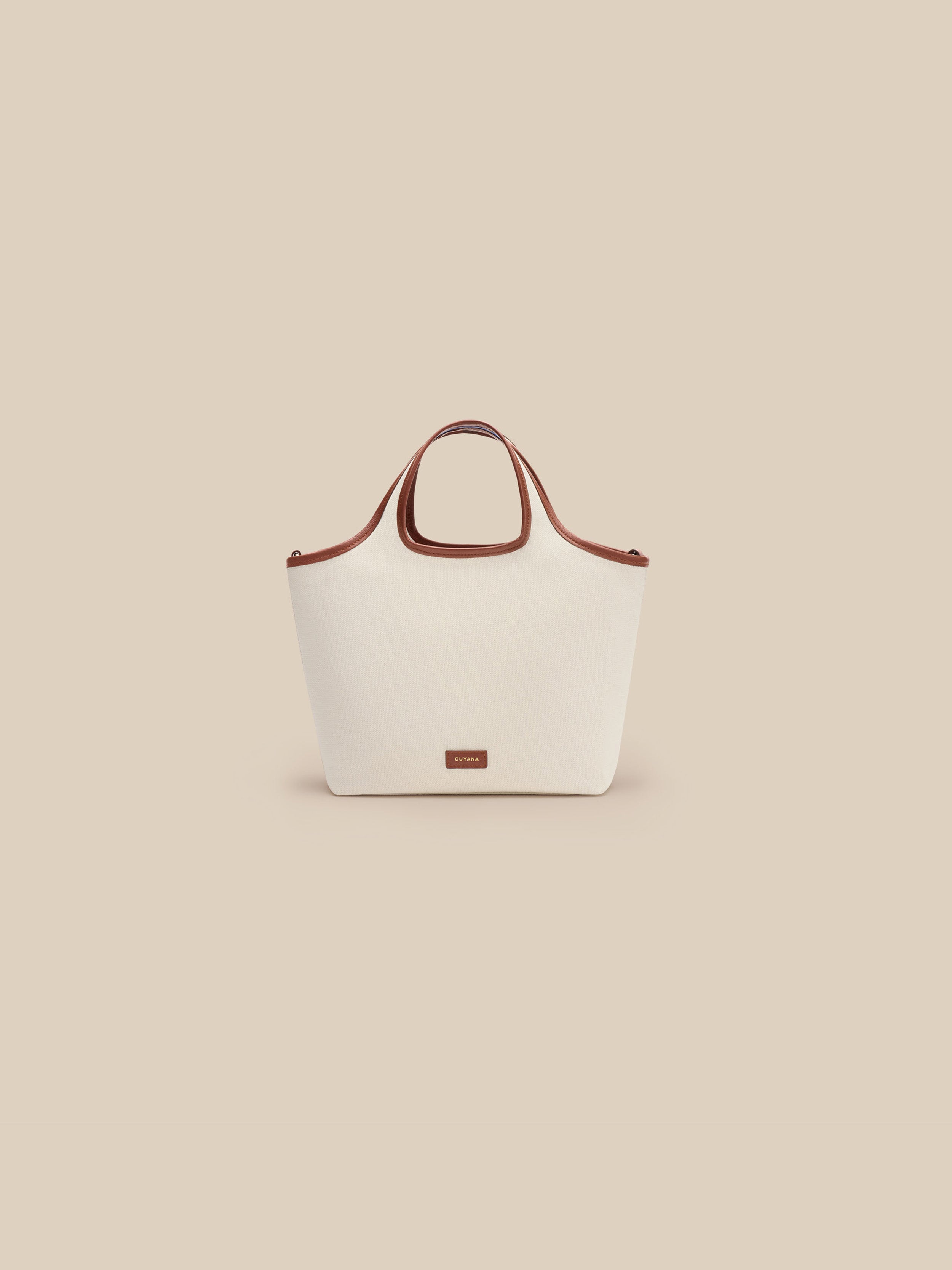 Beige canvas handbag with a beige interior on a beige background
