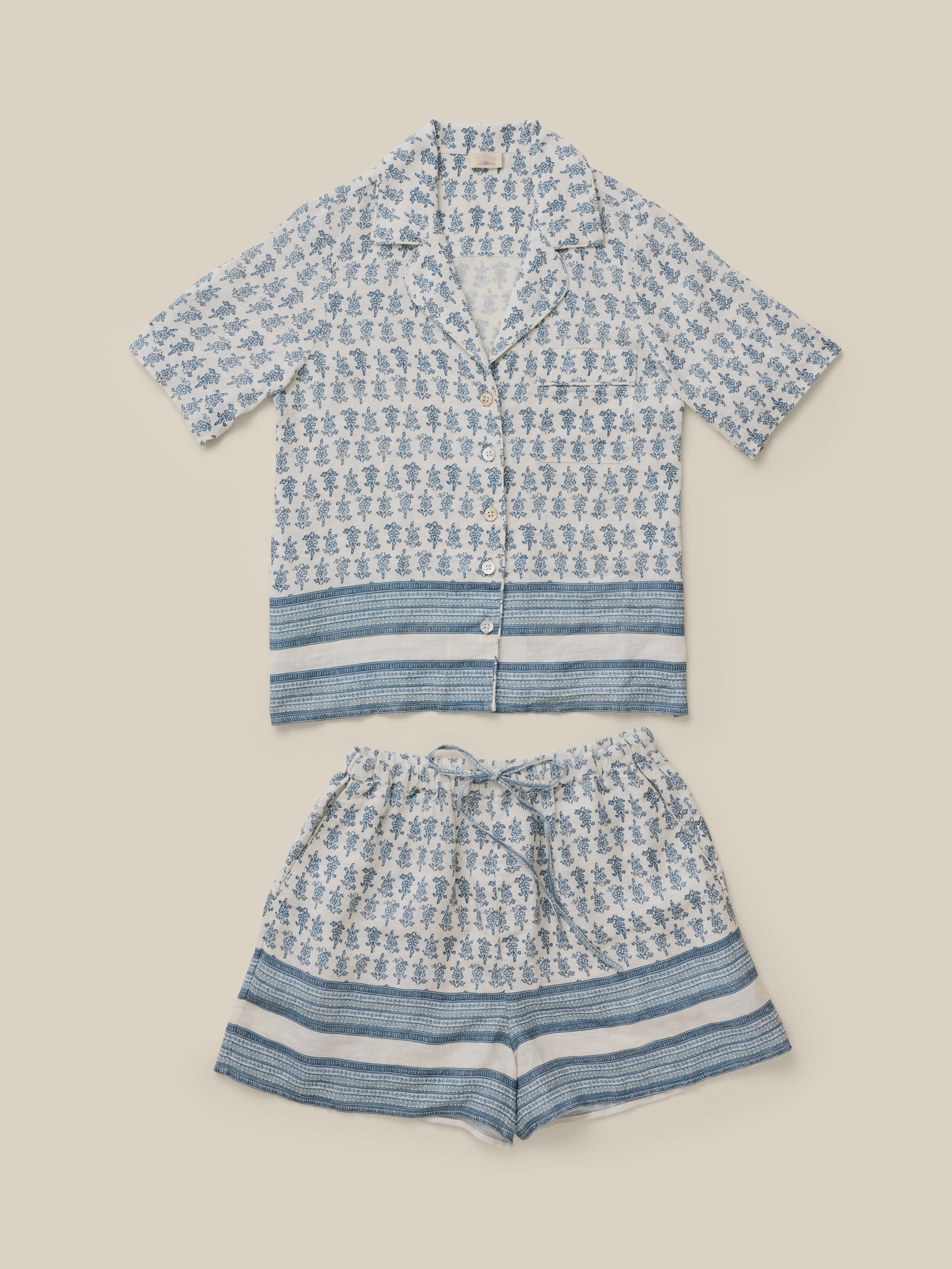 Blue and white patterned shirt and shorts set on a beige background