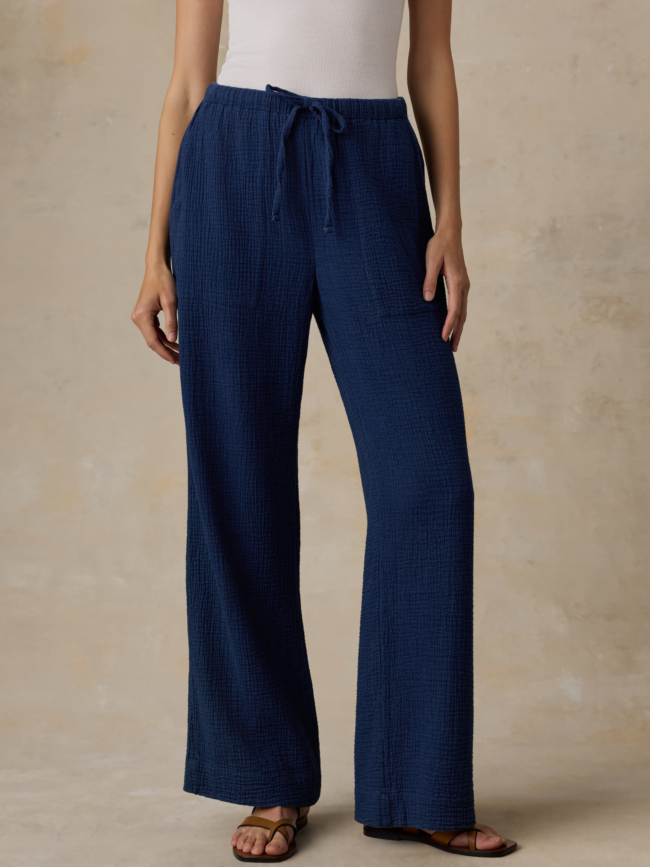 Woman wearing blue pants with a beige background