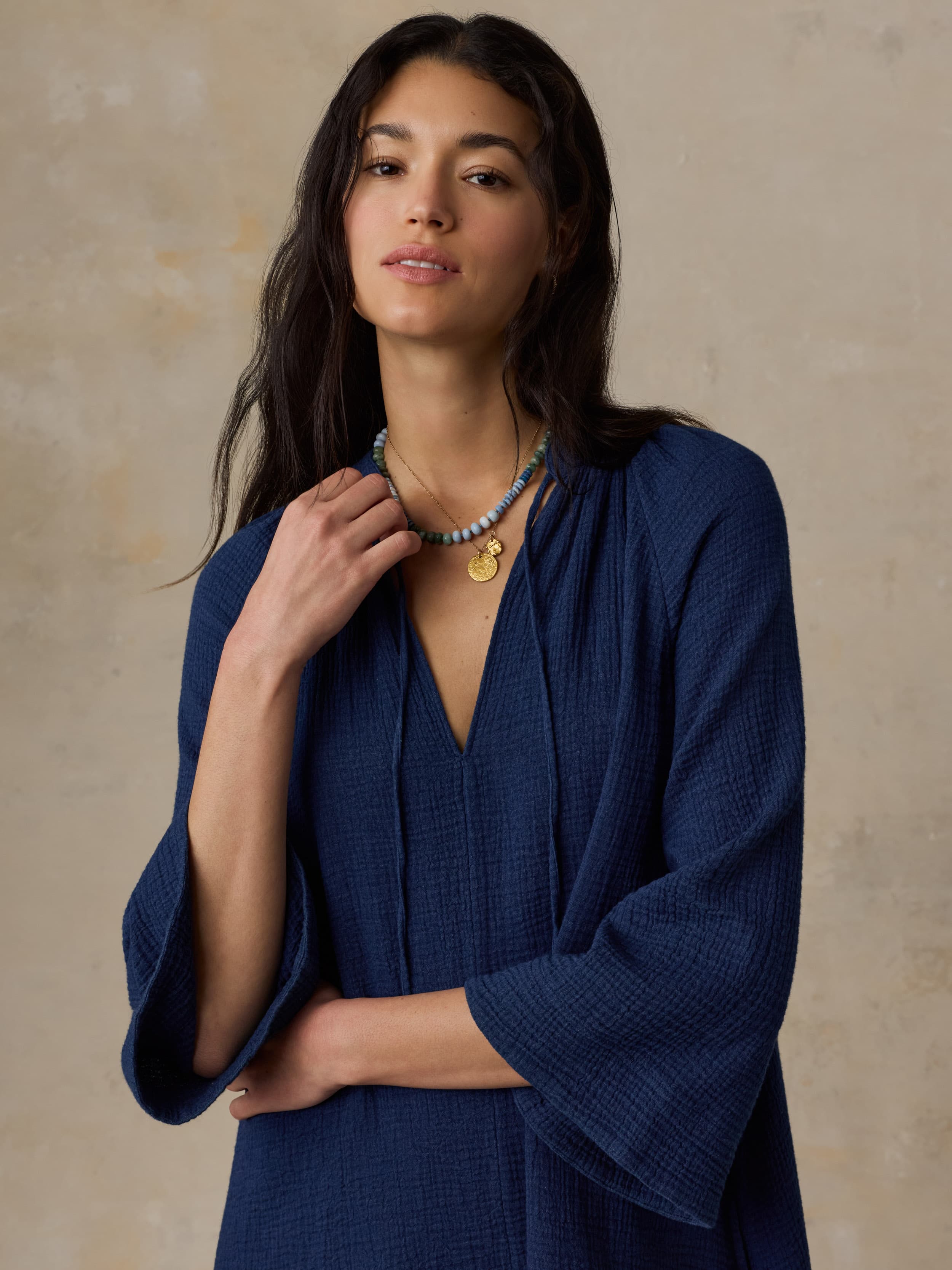 Woman wearing a blue dress against a beige background