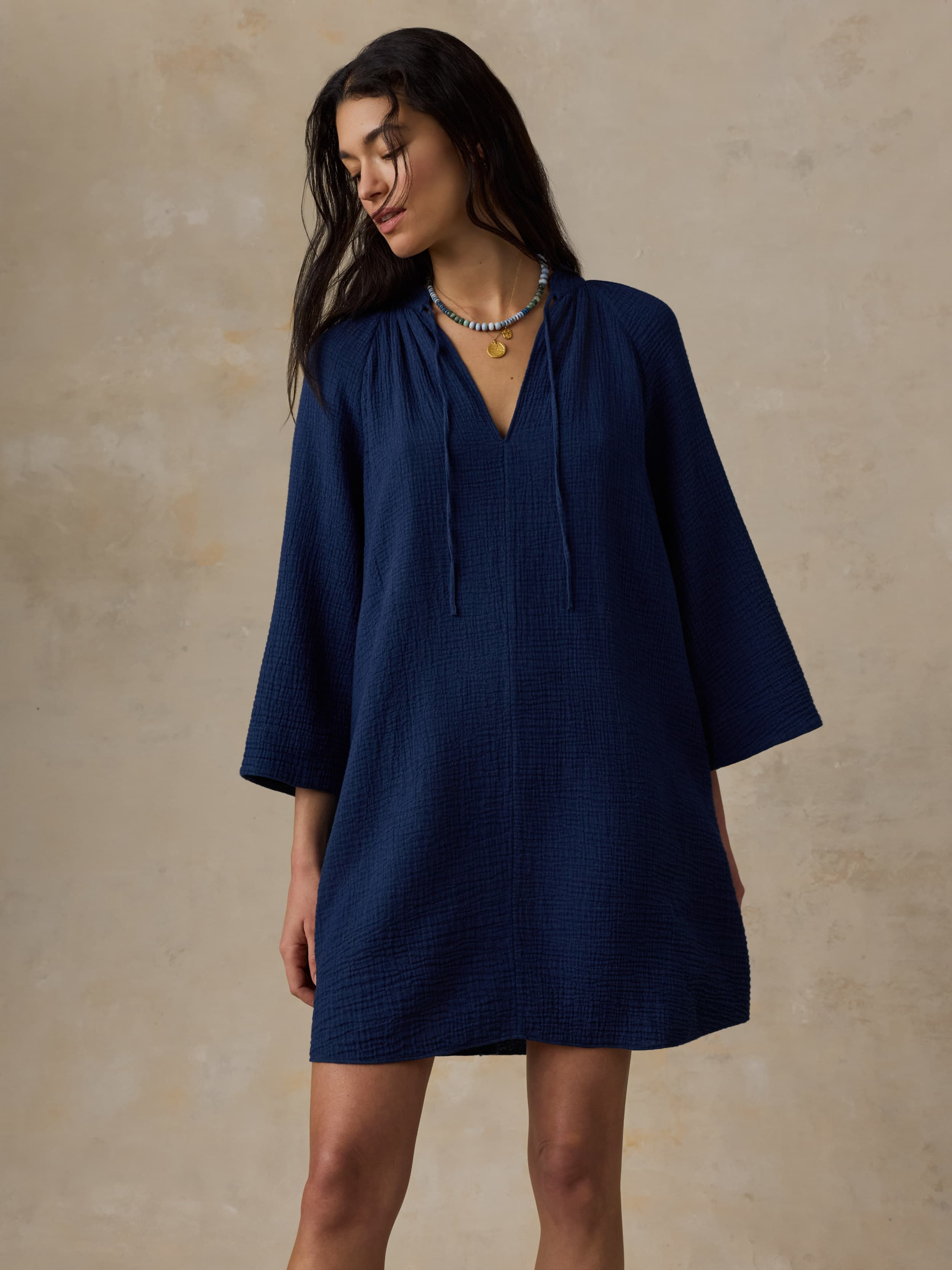 Woman wearing a blue dress against a beige background