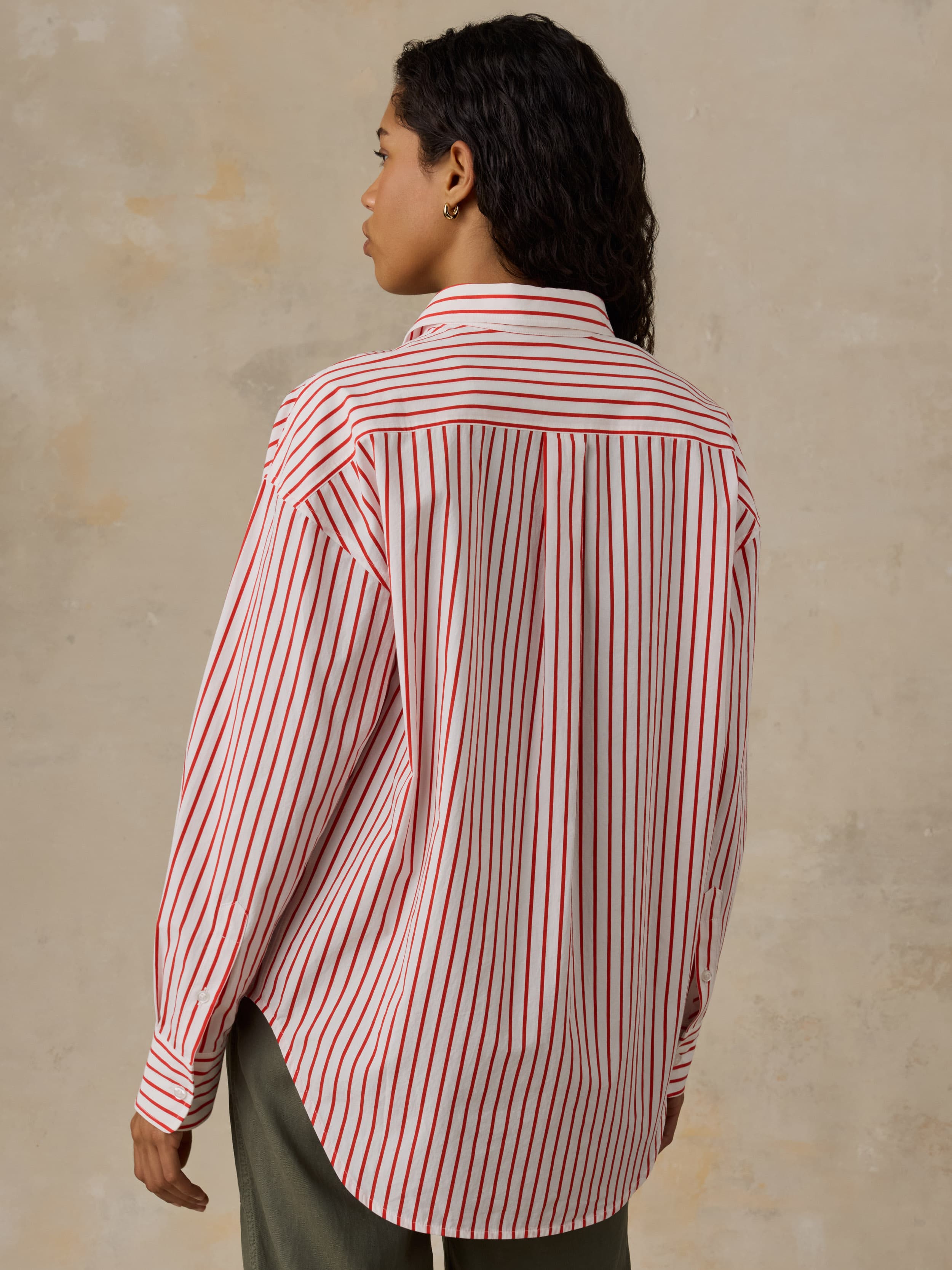 Woman wearing a red and white striped shirt against a beige background